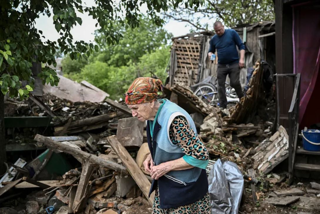 Женщина возле разрушенного ракетным обстрелом дома в городе Бахмуте / Meduza