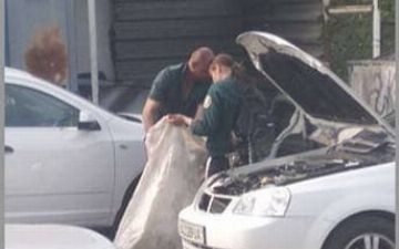 Одетые в форму ОВД мужчина и женщина в Ташкенте собирали макулатуру