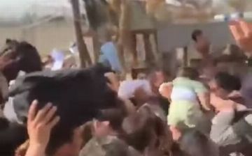 Женщины Афганистана отчаянно умоляли американских военных вывезти детей из страны, передавая их через колючую проволоку в Кабуле - видео
